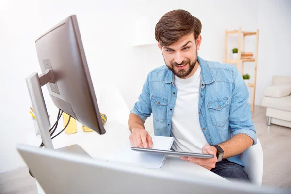 Usmívající se člověk při pohledu na jeho laptopu — Stock fotografie