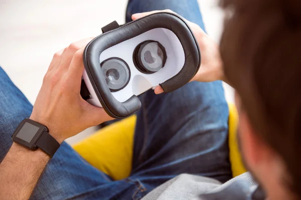 Hombre sosteniendo auriculares de realidad virtual — Foto de Stock