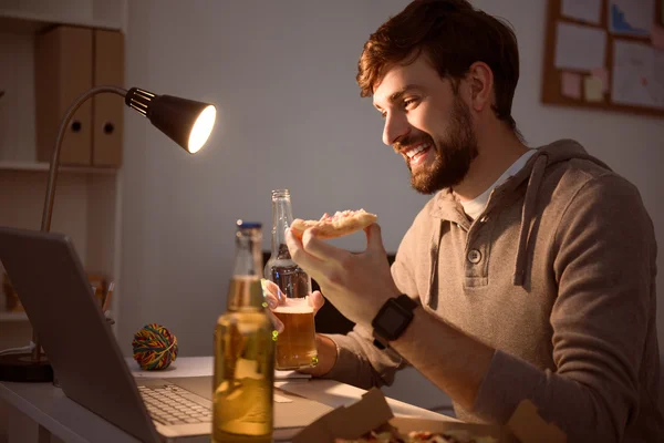 Ember használ laptop és pizzát eszik — Stock Fotó