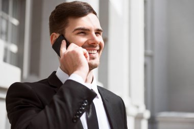 Cep telefonuyla konuşan olumlu gülümseyen adam