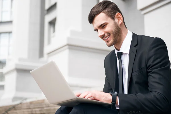 Hombre guapo alegre usando el ordenador portátil — Foto de Stock