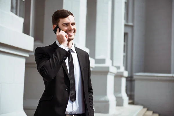 Potěšen, usmívající se muž mluví do mobilního telefonu — Stock fotografie