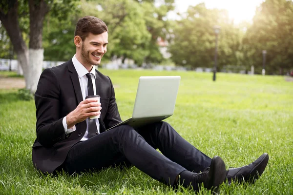 Positiv beglückter Mann sitzt auf dem Rasen — Stockfoto