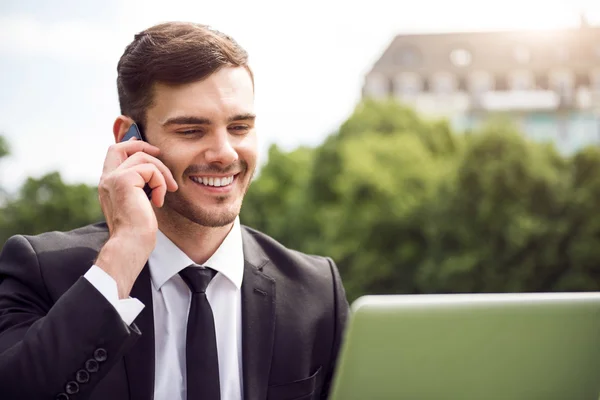 Handsome delighted man sitting on the grass — Stock Photo, Image