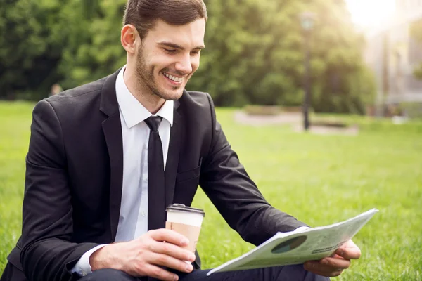 Positieve man zit op het gras — Stockfoto