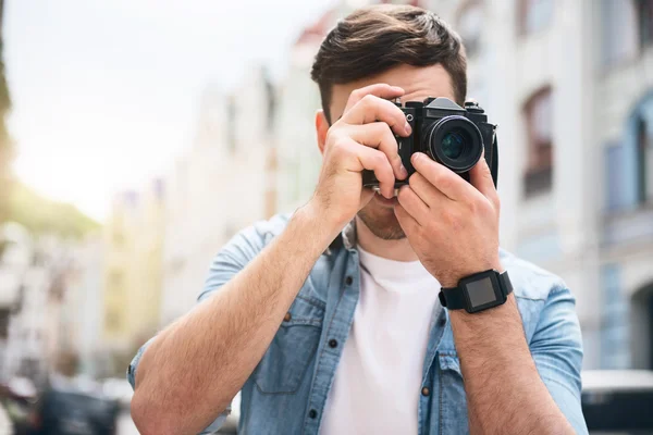 Pleasant cheerful man holding photo camera — Stock Photo, Image