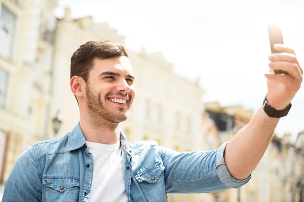 Позитивный человек держит мобильный телефон — стоковое фото
