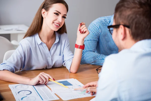 Freudig lächelnde Kollegen am Tisch — Stockfoto