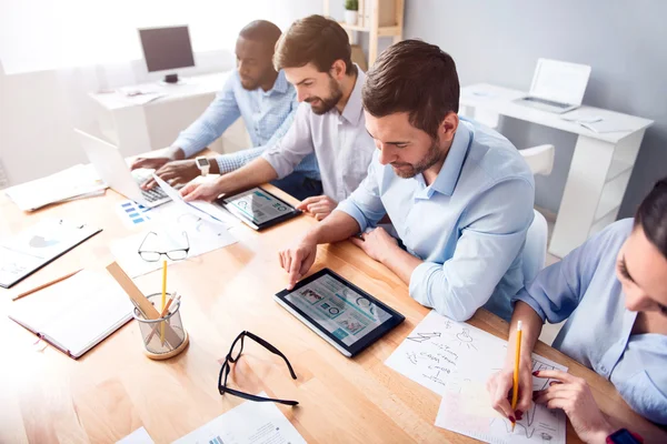 Colegas positivas sentadas a la mesa — Foto de Stock