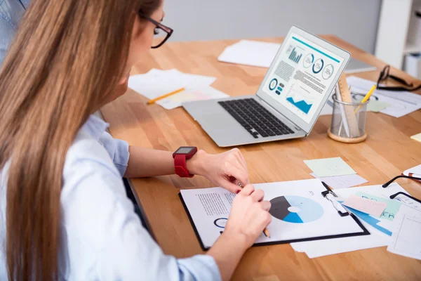 Angenehme schöne Frau sitzt am Tisch — Stockfoto