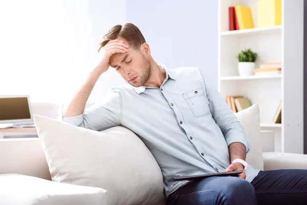 Glädjelös mannen sitter i soffan — Stockfoto