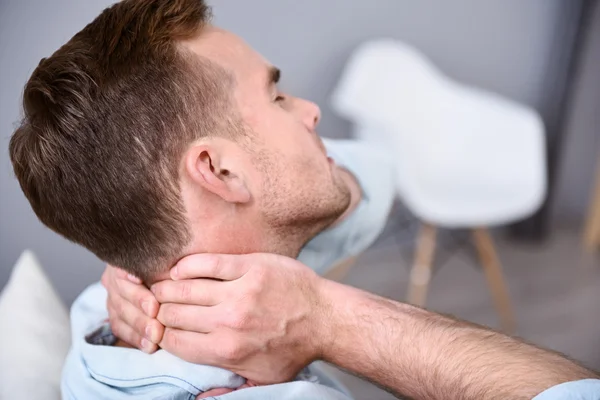 Syg fattig mand sidder på sofaen - Stock-foto