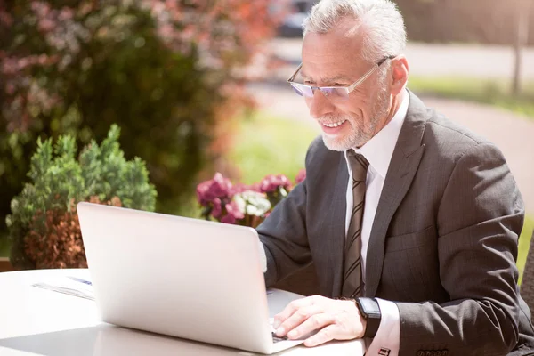 Empresario positivo sentado a la mesa — Foto de Stock