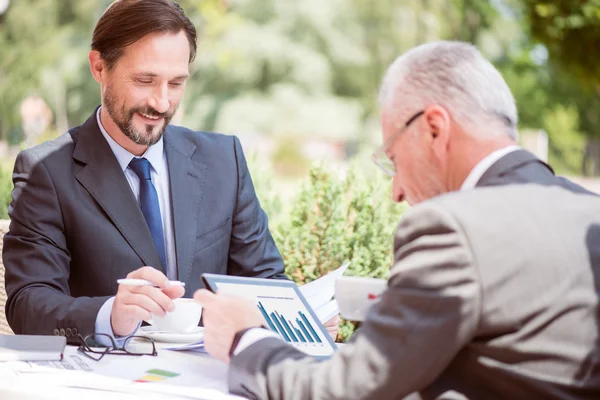 Vrolijke man zit aan de tafel — Stockfoto