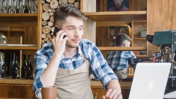 Pleasant barista talking on cell phone — Stock Video