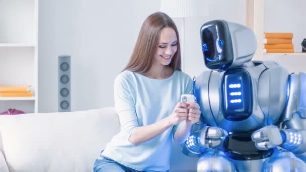 Kvinna sitter i soffan med robot — Stockvideo