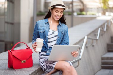 Laptop kullanan neşeli bir kadın.