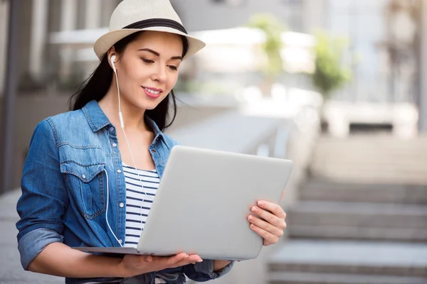 Mulher bonita agradável usando laptop fora — Fotografia de Stock