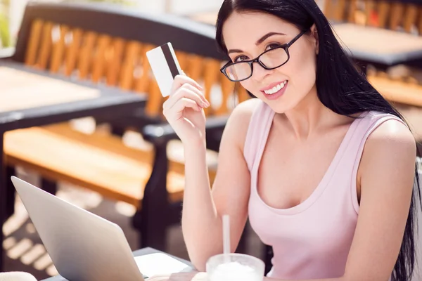 Fröhliche Frau sitzt am Tisch — Stockfoto