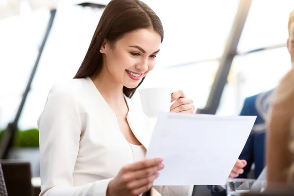 Mujer agradable sentada a la mesa — Foto de Stock