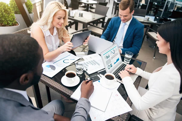 Colegas profissionais positivos sentados à mesa — Fotografia de Stock