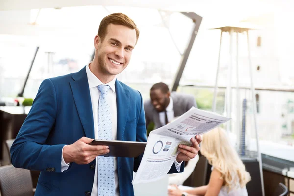 Bonito sorridente homem de pé no escritório — Fotografia de Stock