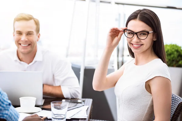 Positieve vrouw zit met haar collega 's — Stockfoto