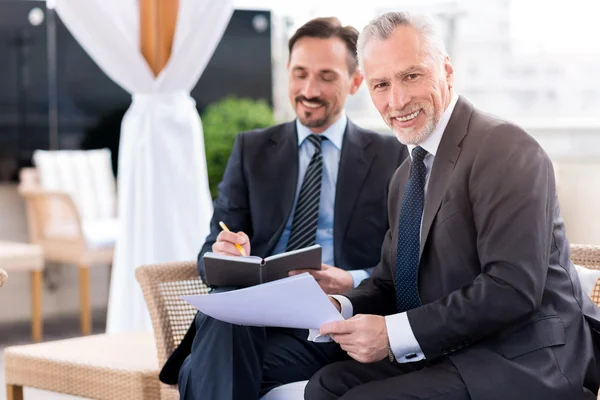 Positiver Mann sitzt mit seinem Kollegen zusammen — Stockfoto