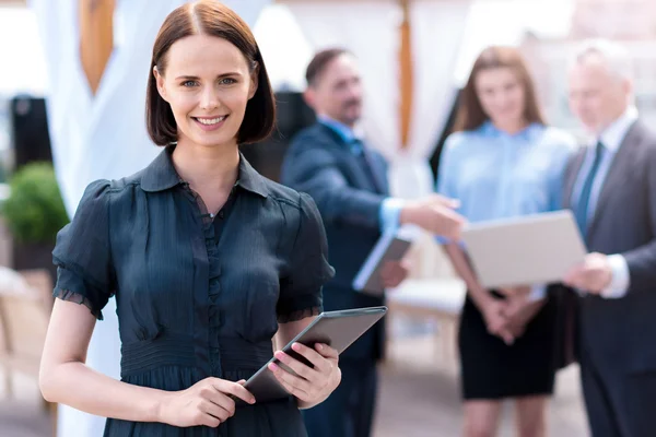 Agradable mujer encantada sosteniendo la tableta — Foto de Stock