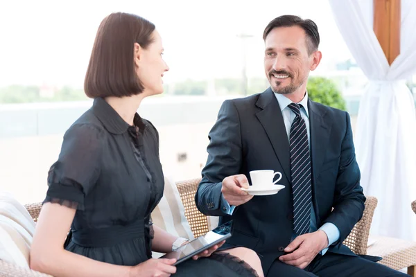 Positieve lachende collega's zitten aan de tafel — Stockfoto