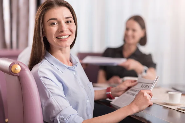 Mujer hermosa positiva sentada a la mesa — Foto de Stock