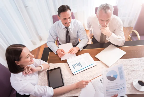 Positieve lachende collega's zitten aan de tafel — Stockfoto