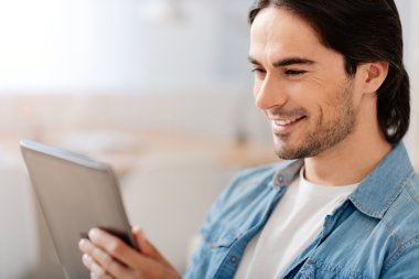 Neşeli gülümseyen adam tablet kullanma