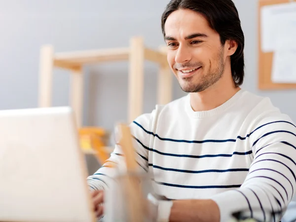 Positieve bebaarde man zit aan de tafel — Stockfoto