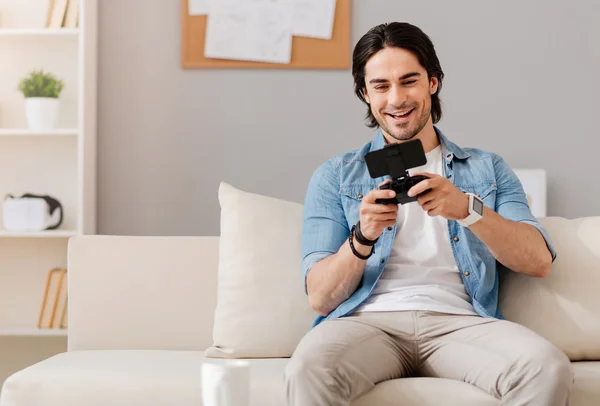 Hombre sonriente positivo jugando videojuegos —  Fotos de Stock