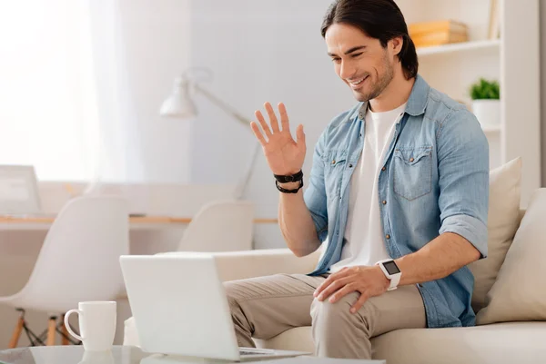 Homem sorrindo positivo falando através da Internet — Fotografia de Stock