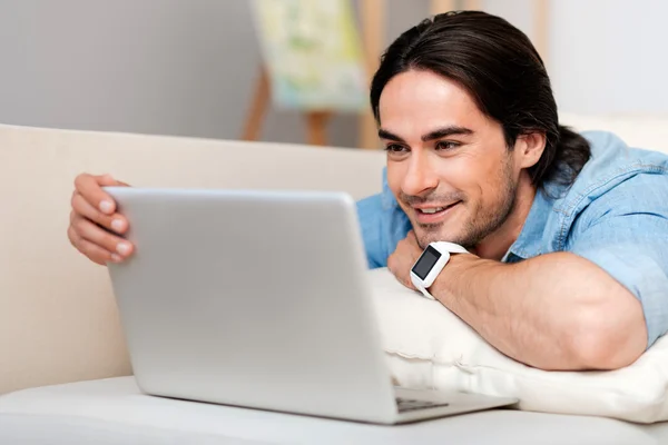 Pozitivní vousatý muž používající přenosný počítač — Stock fotografie