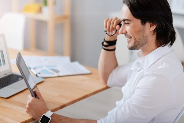 Aangename Glimlachende man zit aan de tafel — Stockfoto