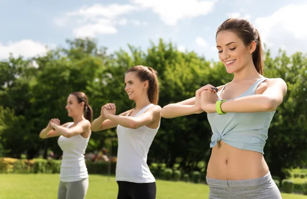 Положительные женщины делают спортивные упражнения на открытом воздухе — стоковое фото
