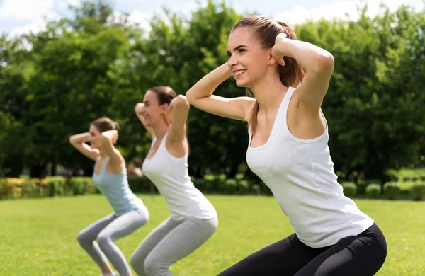 Mulheres alegres fazendo exercícios esportivos — Fotografia de Stock