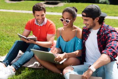 Dizüstü bilgisayar kullanan pozitif ve samimi gençlik