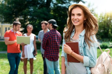 ayakta ve defterini tutan kadın 