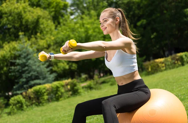Положительная женщина делает спортивные упражнения — стоковое фото