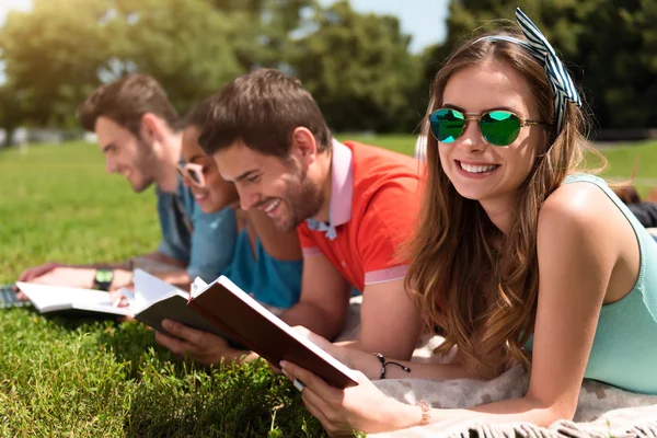 Mujer sosteniendo un copybook con un grupo de estudiantes — Foto de Stock