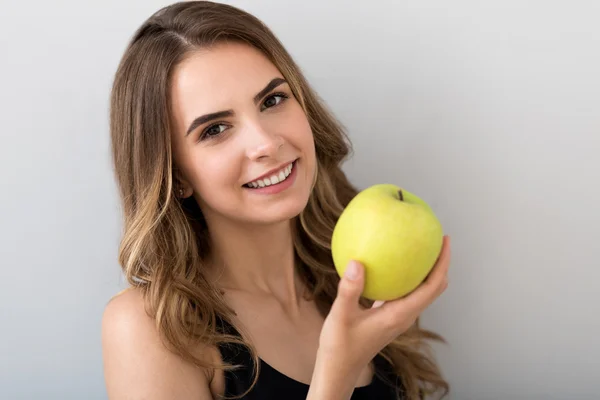 Mulher sorridente alegre segurando maçã — Fotografia de Stock