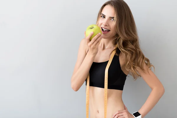 Vrolijke jonge vrouw eten apple — Stockfoto