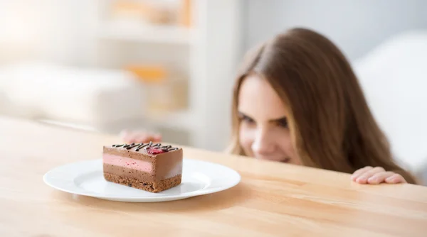 Donna allegra guardando pezzo di torta — Foto Stock