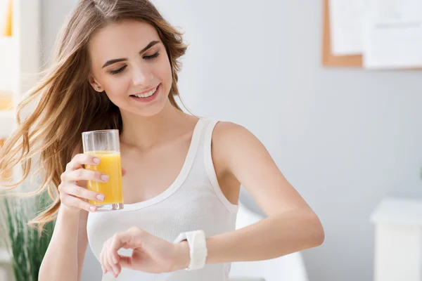 Mulher positiva bebendo suco de laranja . — Fotografia de Stock