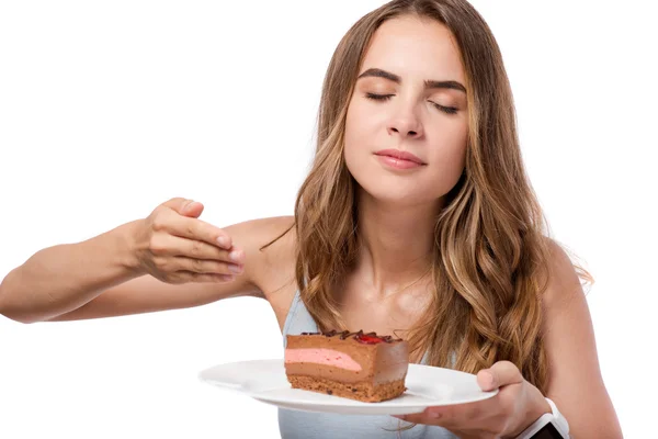 Delighted woman holding plate with piece of cake — Stock Photo, Image