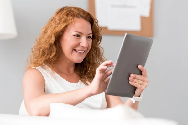 Mujer positiva usando tableta —  Fotos de Stock